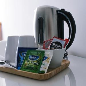 a tray with a tea pot and a cup of tea at Marsuites in Armação de Pêra