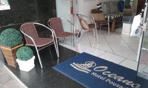 um restaurante com cadeiras e uma placa no chão em HOTEL POUSADA OCEANO em Torres