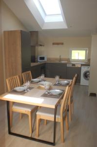 a dining room table with chairs and a kitchen at La Grange d'Etxexuria in Lantabat