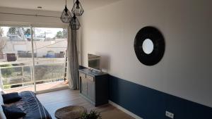 ein Wohnzimmer mit einem Spiegel und einem TV in der Unterkunft JOLI STUDIO 50M DE LA MER in Valras-Plage
