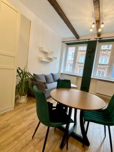 a living room with a table and green chairs at Apartament Gdańsk Centrum Old Town in Gdańsk