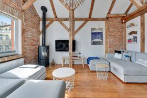 a living room with white furniture and a brick wall at Lion Apartments - Sopot Cosy Attic in Sopot