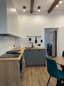 a kitchen with white cabinets and a table and a sink at Apartament Gdańsk Centrum Old Town in Gdańsk
