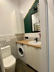 a bathroom with a washing machine and a sink at Apartament Gdańsk Centrum Old Town in Gdańsk