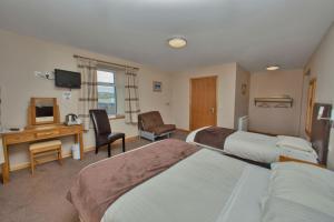 a hotel room with two beds and a desk at Seaview John O Groats Hotel in John O Groats