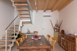 a dining room with a wooden table and wooden stairs at Toson d'Oro Bed & Breakfast in Sabbioneta