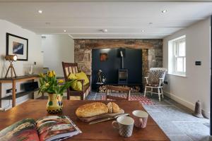 a living room with a table with a loaf of bread on it at Rhif Un- Premium cottage with Log burner & private courtyard in Laugharne