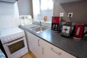 ComblanchienにあるGite La Maison du Tonnelier - Élégance & tradition sur la Route des Grands Crusのシンクとカウンタートップのあるキッチン