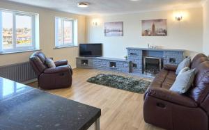 uma sala de estar com dois sofás e uma lareira em Host & Stay - Rock Cottage em Whitby