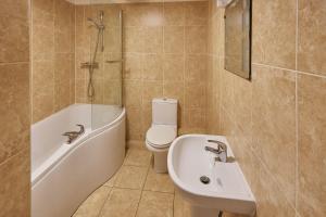 uma casa de banho com um lavatório, uma banheira e um WC. em Host & Stay - Rock Cottage em Whitby