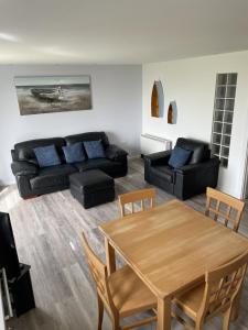 uma sala de estar com uma mesa e um sofá em Beach Front Ground Floor Apartment em Llanelli