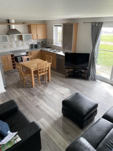a kitchen and living room with a table and a piano at Beach Front Ground Floor Apartment in Llanelli