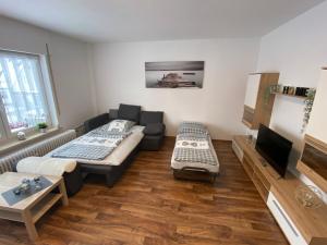 a living room with two beds and a flat screen tv at Apartment - Wohnung bei Nürnberg #1 in Röthenbach an der Pegnitz