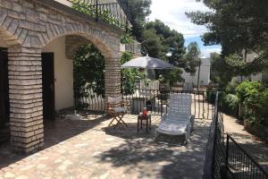 a patio with an umbrella and two chairs and a table at Whole villa in Primošten in Primošten