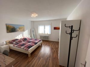 um quarto com uma cama, pisos em madeira e uma janela em Apartment - Wohnung bei Nürnberg #1 em Röthenbach an der Pegnitz