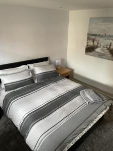Ce lit se trouve dans une chambre ornée d'une peinture murale. dans l'établissement Beach Front Ground Floor Apartment, à Llanelli