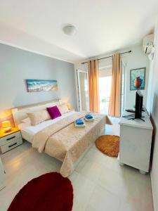 a bedroom with a large bed and a television at ApartHotel Lungo Mare Ulcinj in Ulcinj