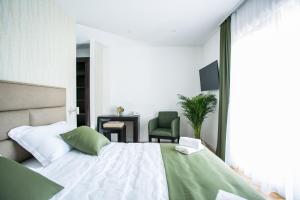 Kaša Rooms 2 في سبليت: غرفة نوم بسرير كبير وكرسي أخضر