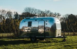 an old trailer sitting in a field of grass at Silver Airstream Glamping & Rental in Chichester