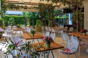 ein Restaurant mit Holztischen, Stühlen und Pflanzen in der Unterkunft Kaša Rooms 2 in Split