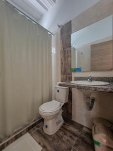 um banheiro com vaso sanitário e pia em Hotel Santa Clara Doradal em Doradal