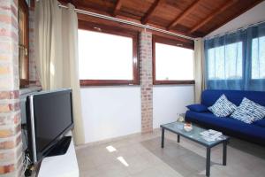 a living room with a blue couch and a tv at Sunset Roof in Anzio