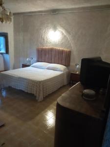 a bedroom with a white bed and a table at IL PIACERE DELLA NATURA in Cansano