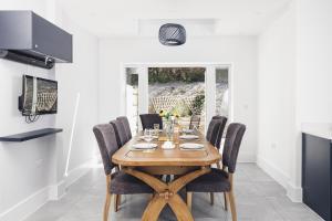 a dining room with a wooden table and chairs at Ocean-Walk Granny's Lane Perranporth in Perranporth