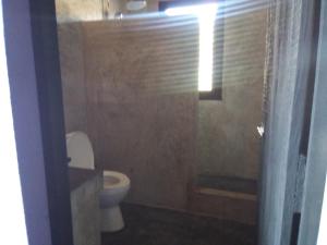 a bathroom with a toilet and a shower with a window at Casa Camilla in Las Galeras