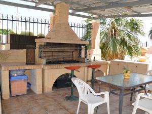 a patio with a table and an outdoor oven at Corfu Sunflower Apartments in Benitses