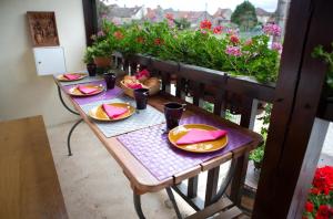 una mesa con platos de comida en un balcón con flores en La Maison du Tonnelier - Élégance & Tradition sur la Route des Grands Crus - 1 à 6 voyageurs en Comblanchien