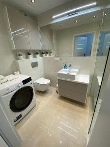 a bathroom with a washing machine and a toilet at Flat4You in Poznań