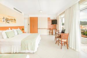 a bedroom with a bed and a table and chairs at Oceania Park Hotel Spa & Convention by RB Hotelaria in Florianópolis +22 photos