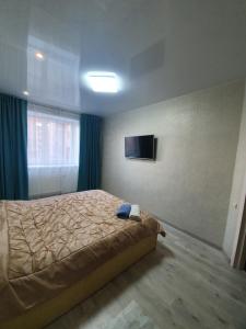 um quarto com uma cama e uma televisão na parede em ЖК Яровиця em Lutsʼk