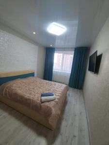 um quarto com uma cama grande e cortinas azuis em ЖК Яровиця em Lutsʼk