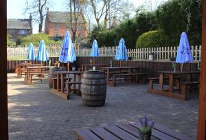 un groupe de tables en bois avec des parapluies bleus dans l'établissement The Castle Inn, à Dirleton