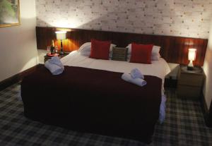 The Castle Inn في Dirleton: غرفة فندق بسرير كبير عليها مناشف