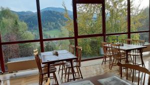 a room with tables and chairs and a large window at Ośrodek Wczasowy PANORAMA Szczyrk in Szczyrk