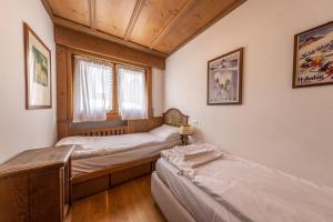 um quarto com 2 camas e uma janela em Casa Pecol em Cortina dʼAmpezzo