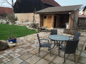 a patio with a table and chairs in a yard at Ferienhaus Villa Kunnibunt in Burgsalach