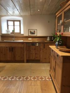 a large kitchen with wooden cabinets and a sink at Ferienhaus Villa Kunnibunt in Burgsalach