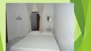 um quarto branco com uma cama e um lavatório em Kit Net, No Centro Comercial de Belém em Belém