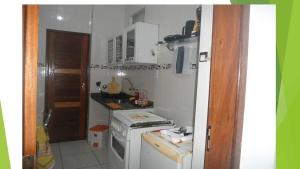a small kitchen with a white stove top oven at Kit Net, No Centro Comercial de Belém in Belém