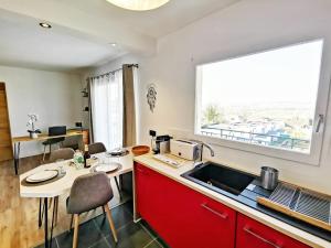 cocina con fregadero, mesa y ventana en Le 79 Reflet de la Marne, en Noisy-le-Grand