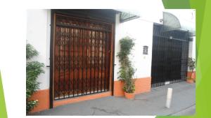 a wooden door with a black gate on a building at Kit Net, No Centro Comercial de Belém in Belém