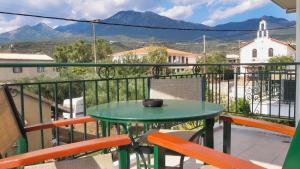 a balcony with a table and chairs and mountains at Vasiliki Apartments in Stoupa