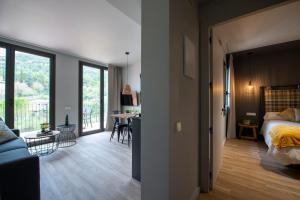 1 dormitorio y sala de estar con 1 cama y 1 mesa en Apartaments Agulles de Montserrat, en Monistrol