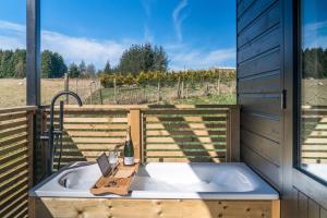 a bath tub with a bottle of wine and a bottle of wine at The Trossachs Collection in Kepculloch