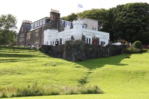 a large white house on a grassy hill at Flodigarry Hotel and SKYE Restaurant in Staffin