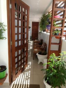 a hallway with a wooden door and some plants at Cantinho Aconchegante 304 Praia - Tambaú in João Pessoa